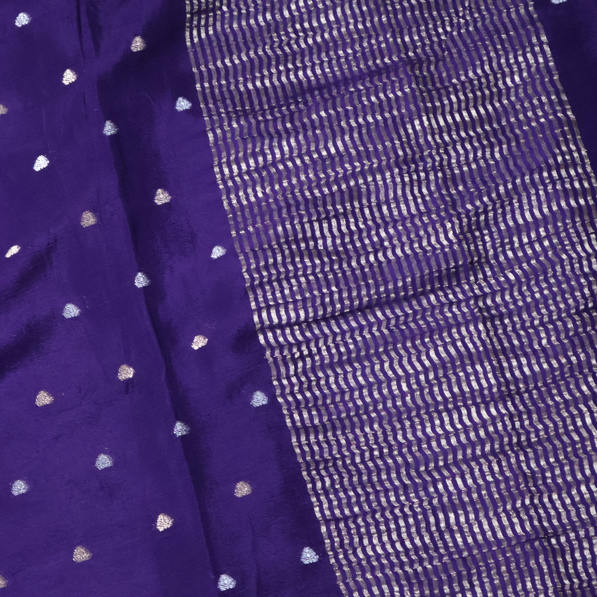 Close-up of a purple saree with white heart patterns, pallu and a textured border.