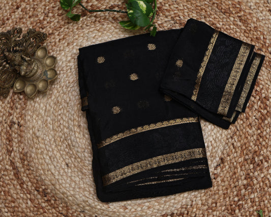 Black saree with gold embroidery on a textured surface